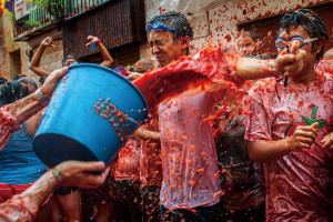 BUNOL, SPAIN - AUGUST 28: Revellers celebrate covered by tomato pulp while participating the annual Tomatina festival on August 28, 2013 in Bunol, Spain. An estimated 20,000 people threw 130 tons of ripe tomatoes in the world's biggest tomato fight held annually in this Spanish Mediterranean town. (Photo by David Ramos/Getty Images)